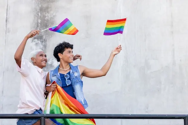 dos personas con banderas de la comunidad LGTBIQ+